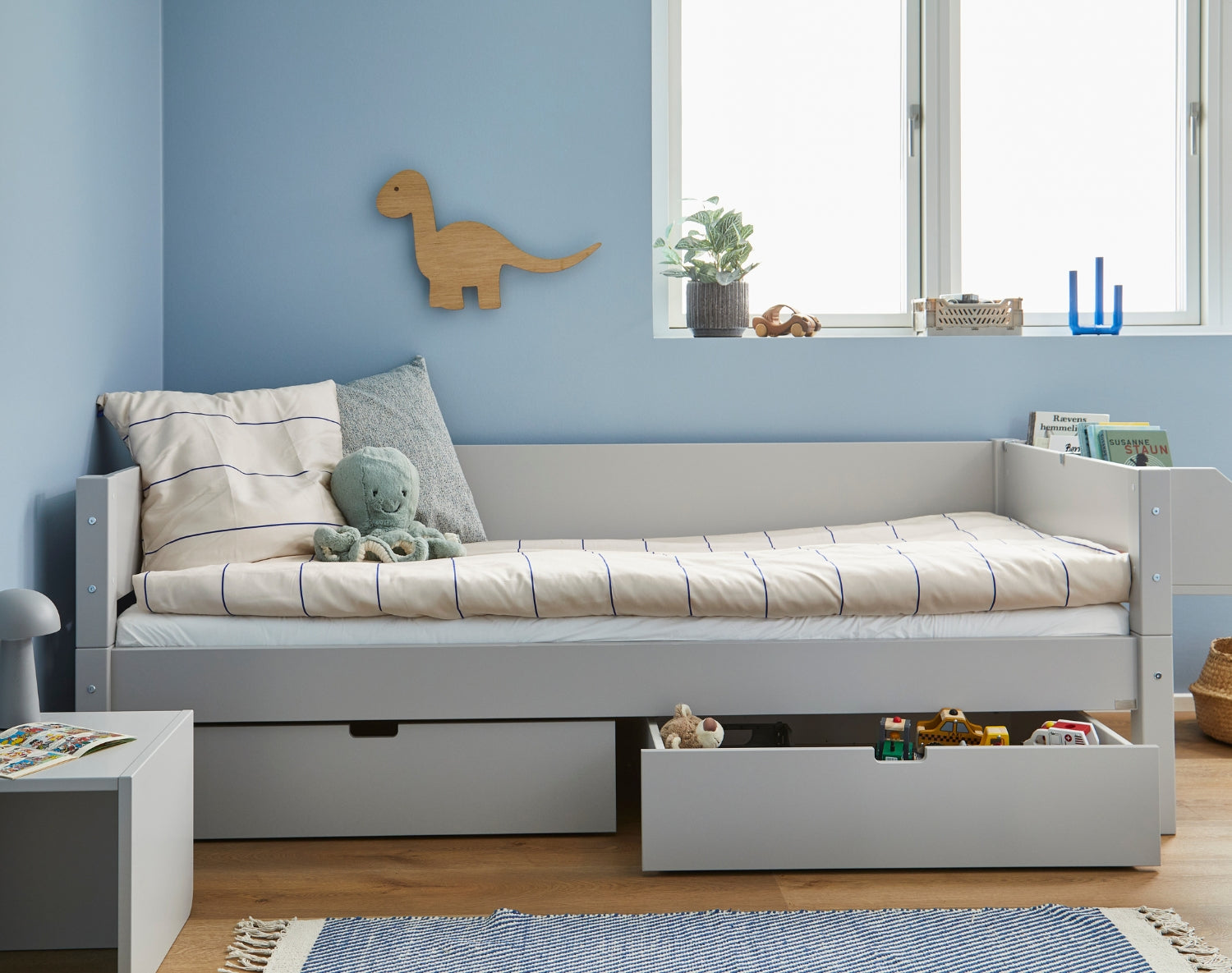 Sif børneseng med skuffer i lyst træfarvet, pyntet med bamser og legetøj