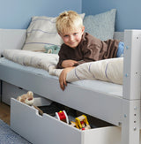 Glad dreng i Sif børneseng med udtræksskuffer og legetøj