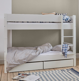 Hvid køjeseng med stige, opbevaringsskuffer og farvede puder