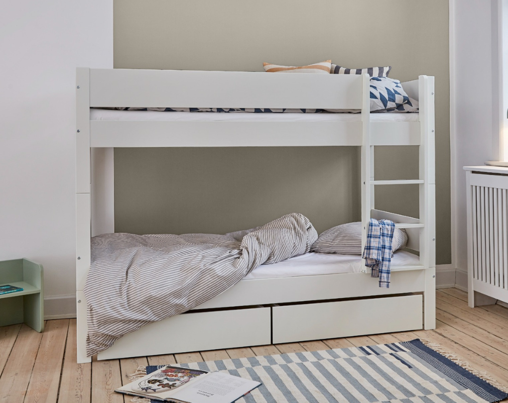 Hvid køjeseng med stige, opbevaringsskuffer og farvede puder